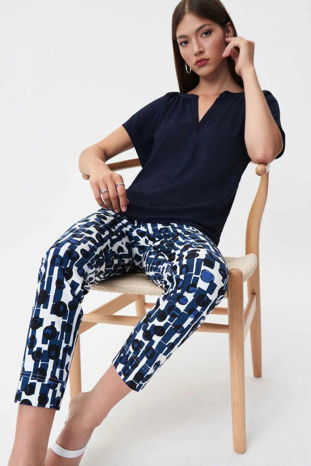 Flared Split Neck Top Style 232023 Seated in Chair.